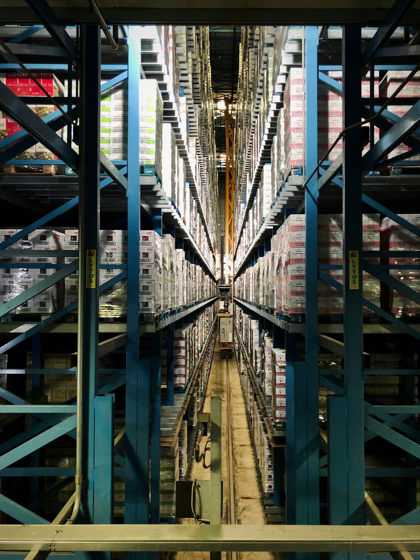 High-bay warehouse racking holding ingredient, packaging and finished-goods stock tracked by lot and expiry