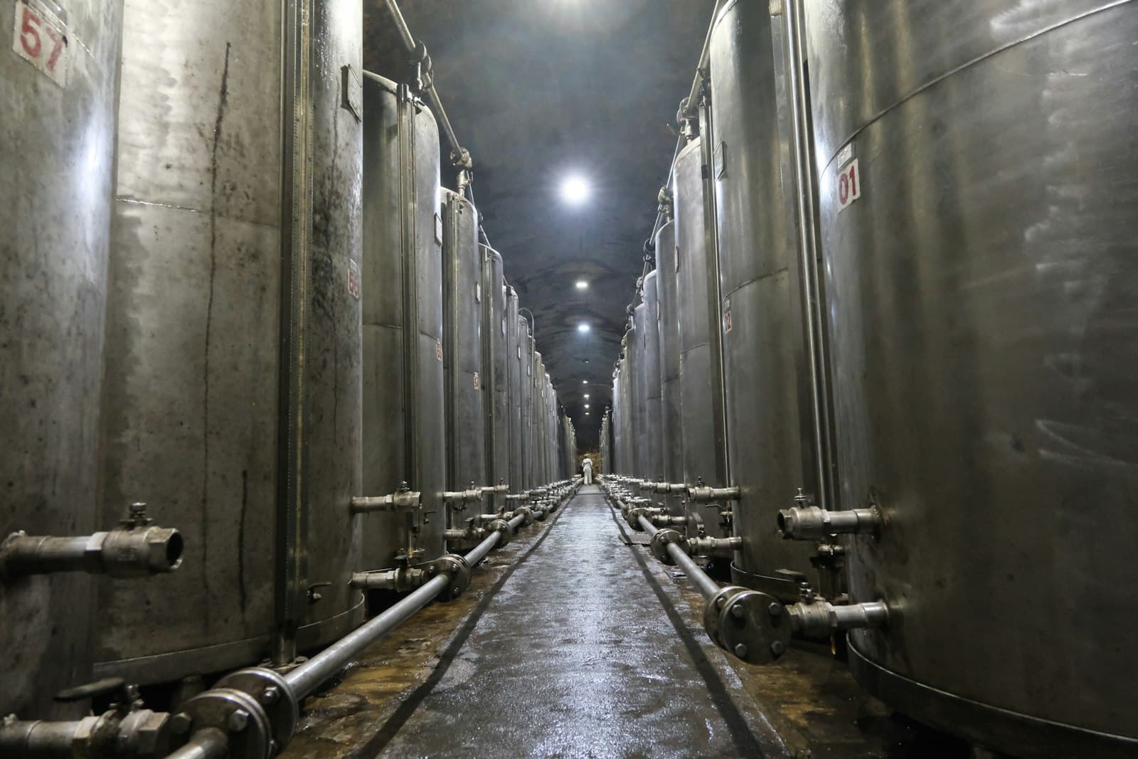 Long hall of large stainless steel storage tanks used for liquid ingredients