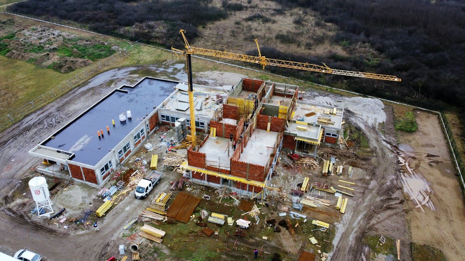 Aerial view of a construction site with a tower crane, new building blocks and access roads