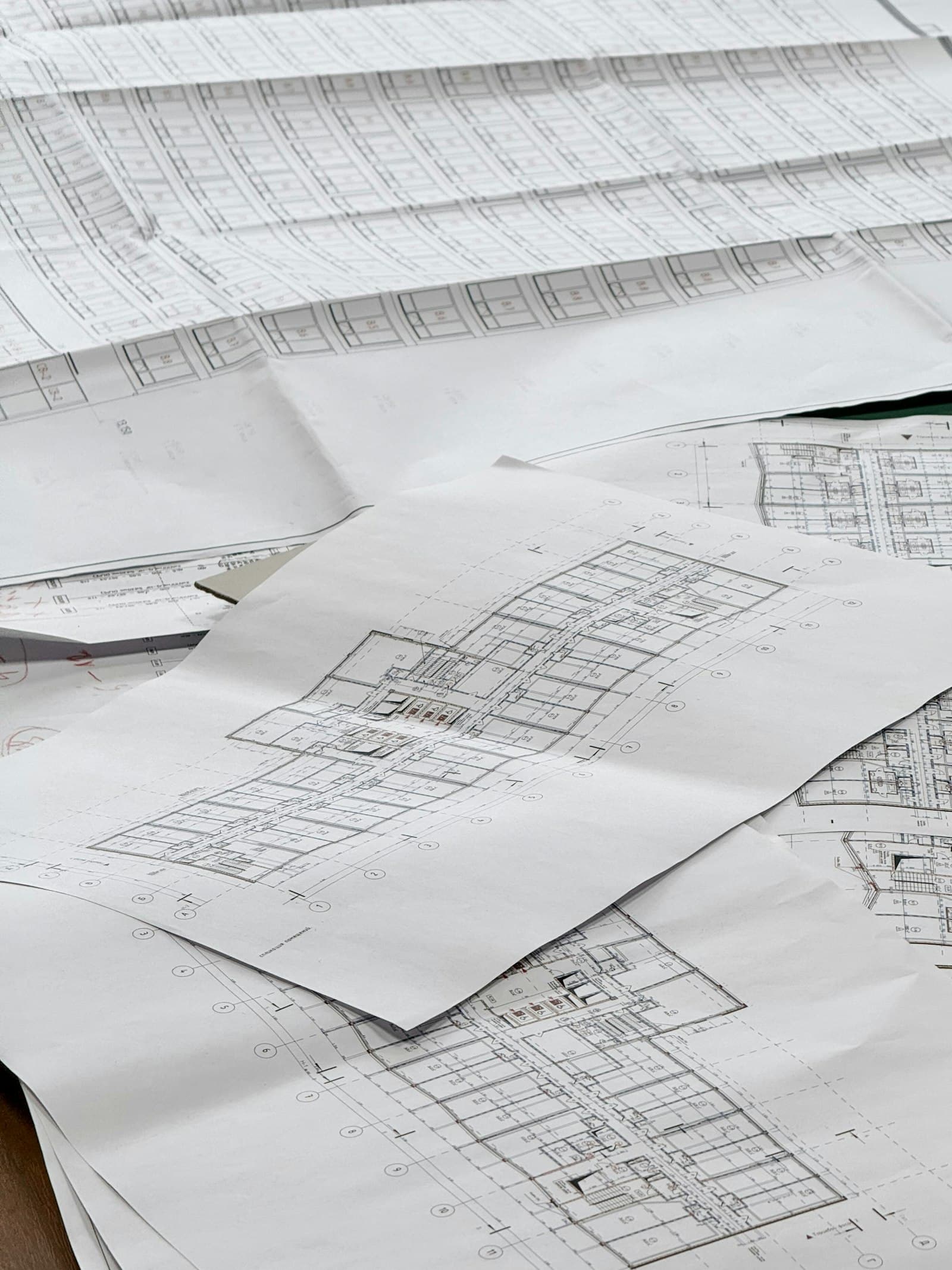 Architectural floor plan drawings spread across a table
