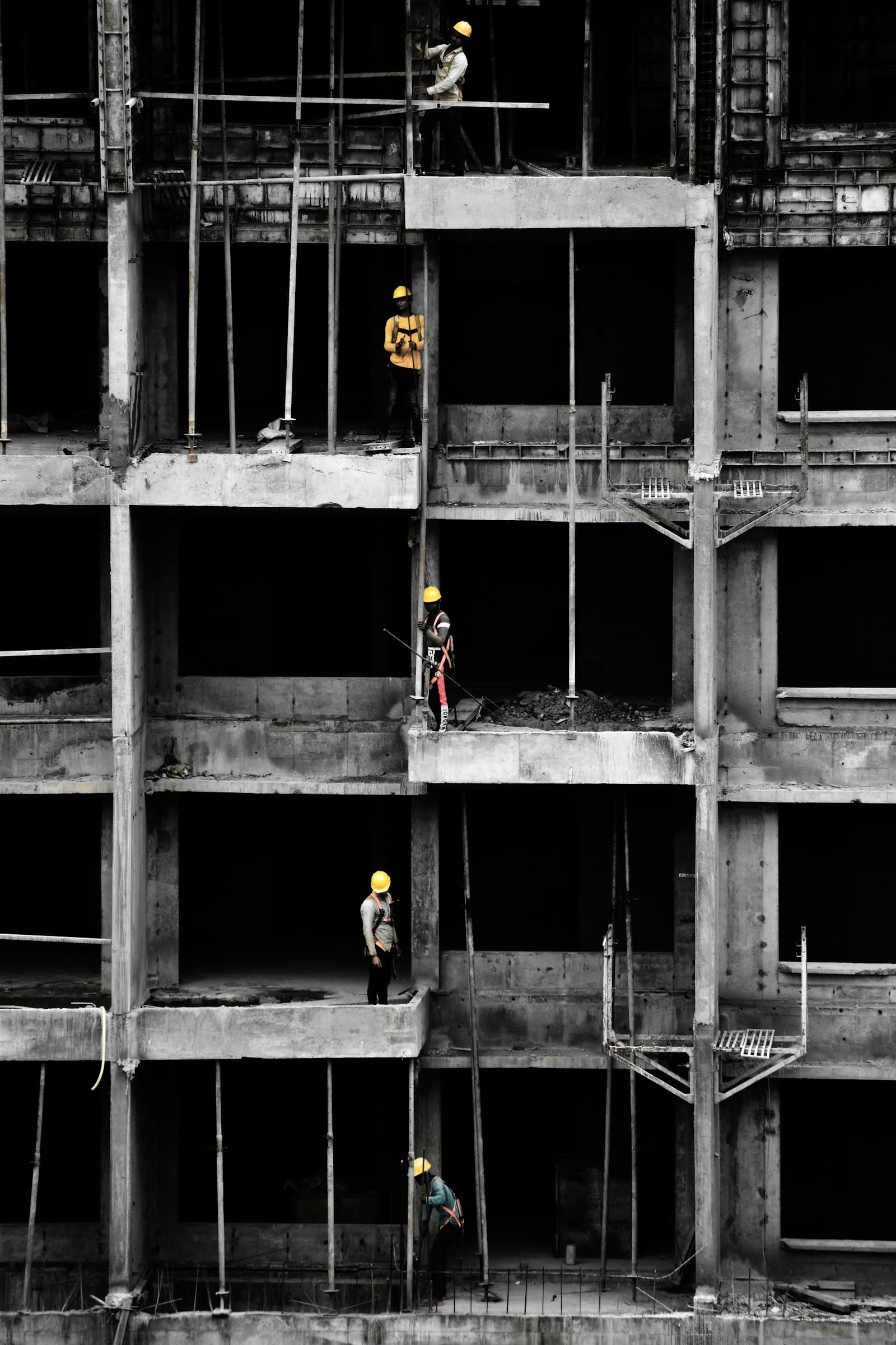 Workers on the open concrete frame of a multi-storey building under construction