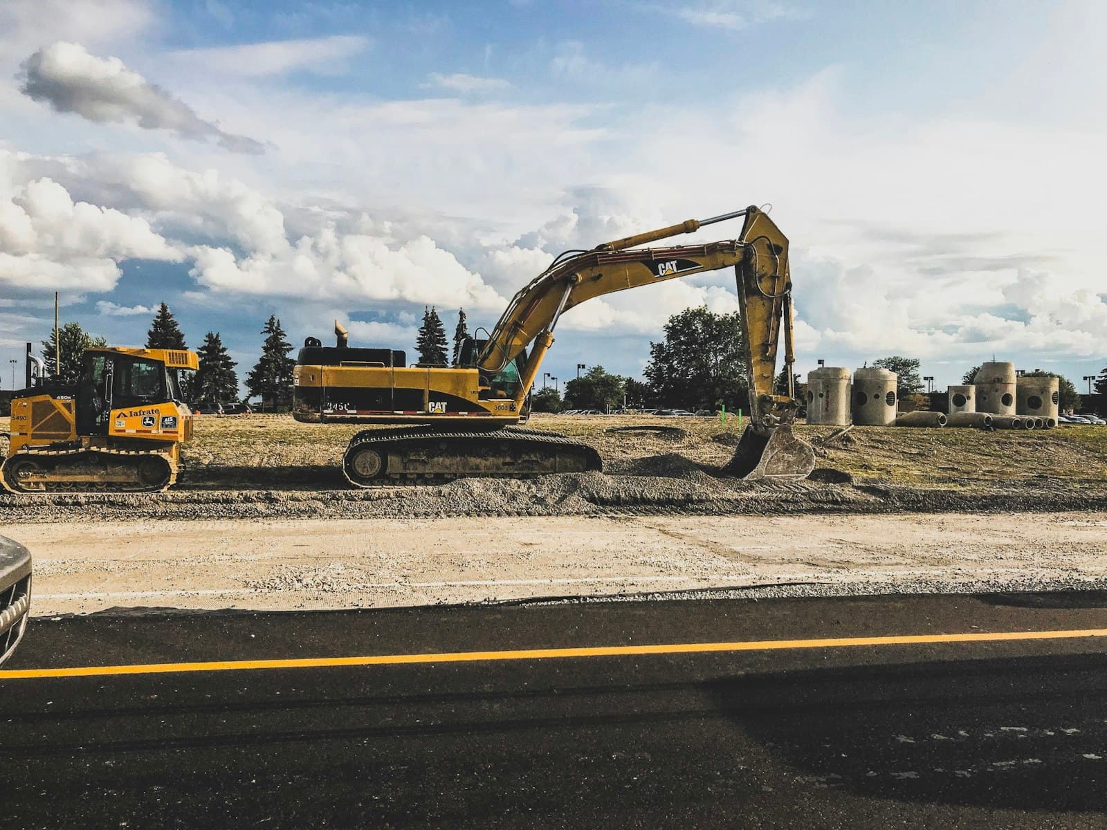 Yellow excavator and earthmoving equipment working on a large civil site
