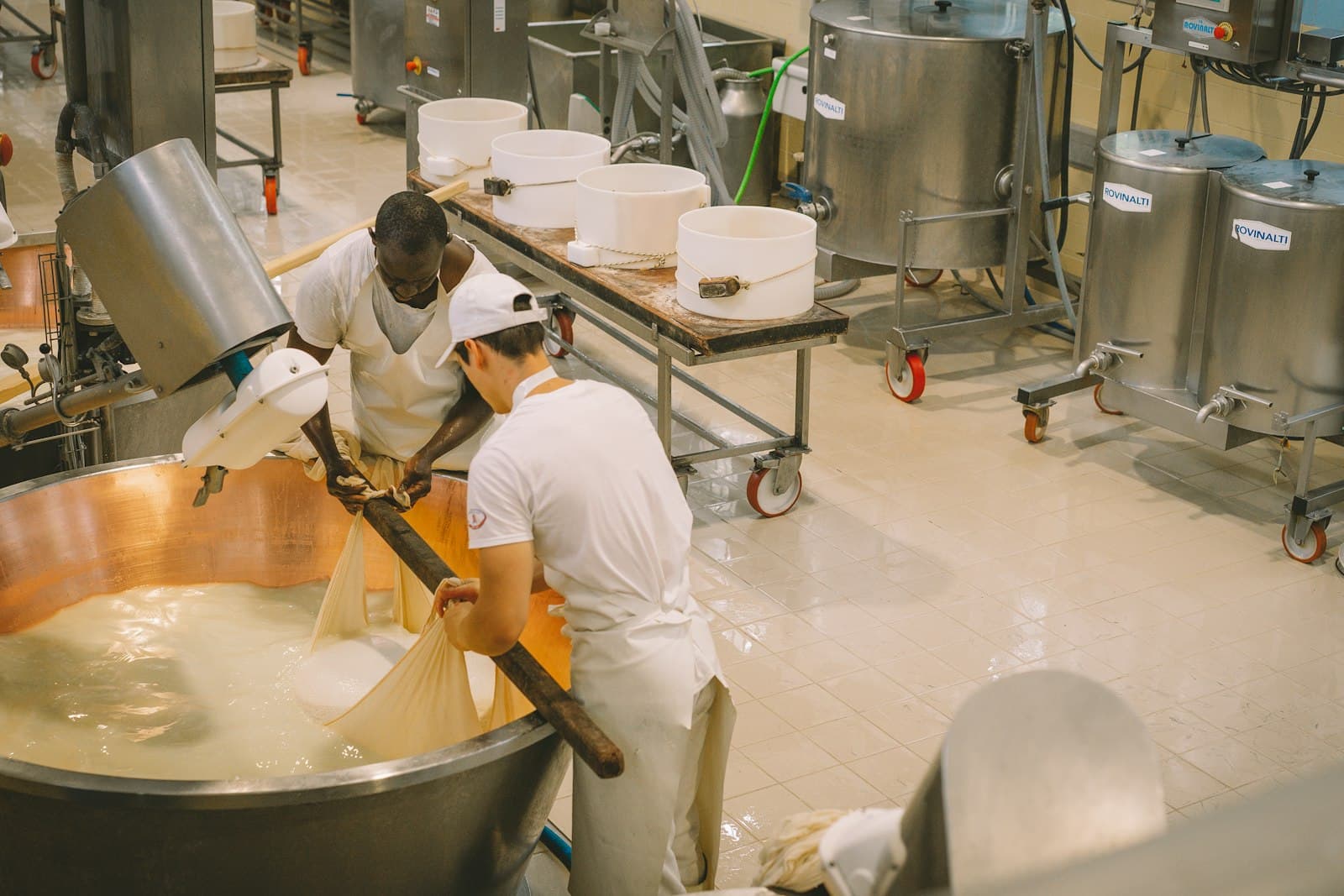 Dairy plant staff working at a large processing vat