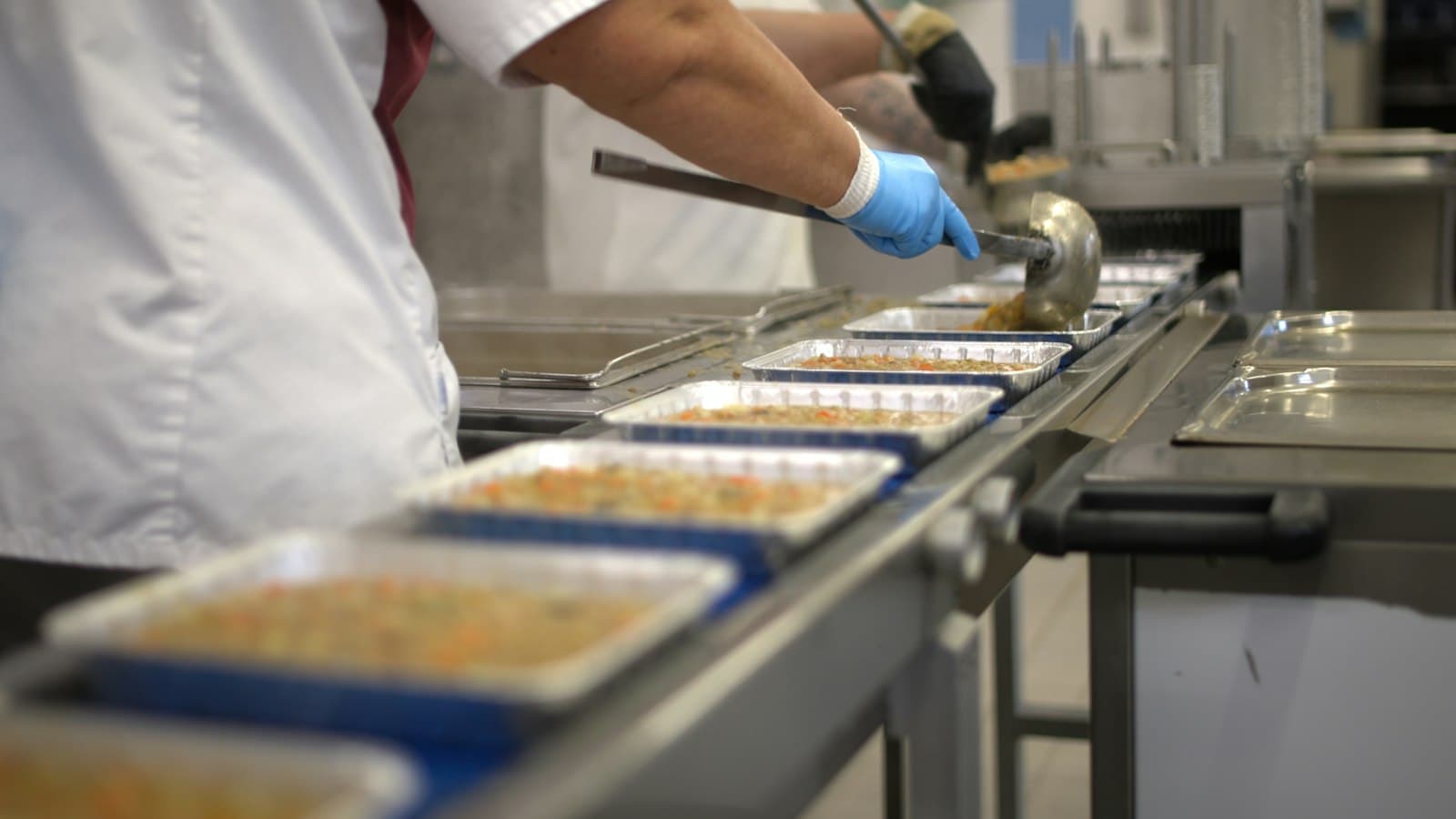 Food trays being filled on a packaging conveyor