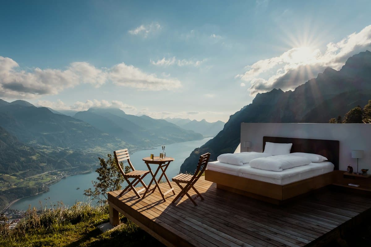 Hotel bed overlooking a mountain valley, for travel marketplace booking app development